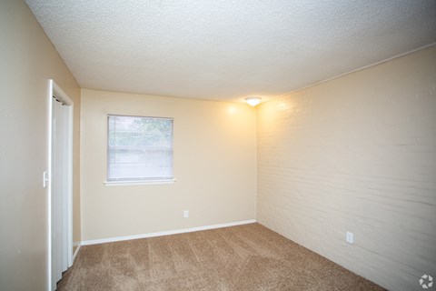 the interior of a bedroom with carpet and a window